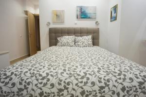 a bedroom with a bed with a black and white comforter at Porto Rafti view by Akroploro in Porto Rafti