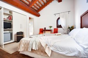 a white bedroom with a large bed and a tv at Hotel Due Mori in Marostica +31 photos