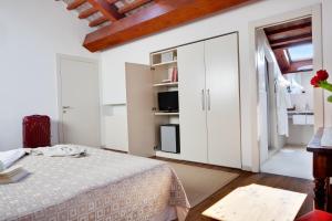 a white bedroom with a bed and a tv at Hotel Due Mori in Marostica