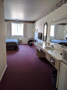 a hotel room with two beds and a desk at Lighthouse Inn in Crescent City