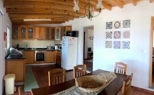 a kitchen with a table and a white refrigerator at Azorean Cottage São Jorge in Cais da Urzelina