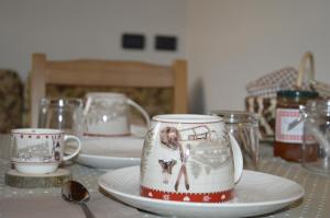 a table with cups and plates on a table at Au Coin Du Chateau in Châtillon