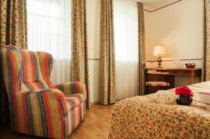 a hotel room with a bed and a chair at Landgasthof & Hotel Jagdhof in Stralsund +23 photos