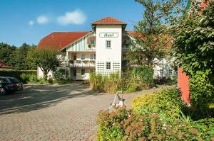 un gran edificio blanco con un cartel. en Landgasthof & Hotel Jagdhof, en Stralsund