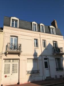 ein großes weißes Gebäude mit zwei Balkonen darauf in der Unterkunft Deauville Triangle d OR in Deauville