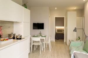 Una cocina y una sala de estar con mesa y sillas. en Les Suites - Apartments, en Riposto