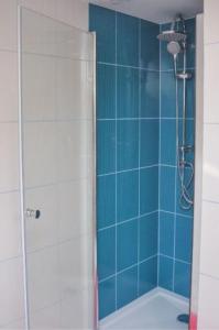 een badkamer met een douche met blauwe tegels bij Nocleg w Małastowie in Małastów