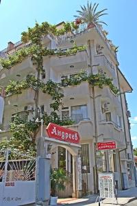 un edificio de apartamentos con un letrero en la calle delante de él en Family Hotel Andreev en Nesebar