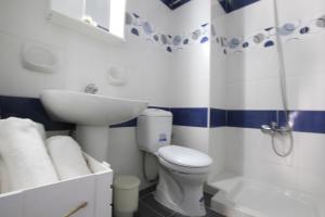 
a white toilet sitting next to a white bath tub at Christiana Hotel Apartments in Gennadi
