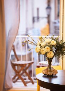 um vaso cheio de rosas amarelas sentado numa mesa em Stay In Ortigia em Siracusa
