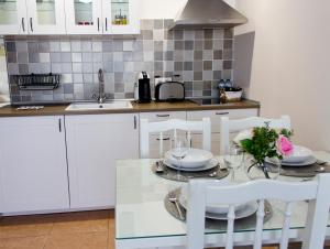 a kitchen with white cabinets and a table and chairs at Felisa Center in Arrecife