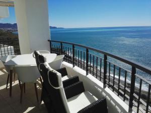 ein Balkon mit Tisch und Stühlen und dem Meer in der Unterkunft Apartamento Lujo Calaceite in Torrox Costa