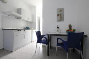 
a kitchen with a table and chairs and a refrigerator at Christiana Hotel Apartments in Gennadi
