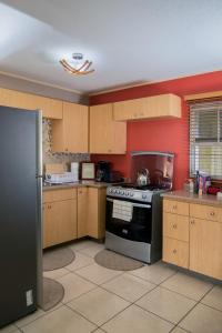 a kitchen with wooden cabinets and a stove top oven at Country Club Comfort in Portmore