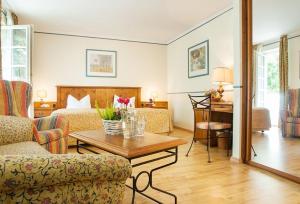 - un salon avec un lit et une table basse dans l'établissement Landgasthof & Hotel Jagdhof, à Stralsund