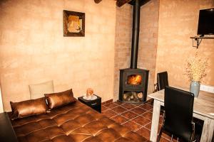 uma sala de estar com um sofá e uma lareira em Apartamentos Rurales El Casarejo em Cantalojas