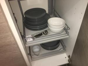 a stack of plates and bowls on a shelf in a refrigerator at Catalans in Marseille