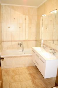 een badkamer met een bad, een wastafel en een bad tubermott bij Centrum Apartman with Free Parking in Győr