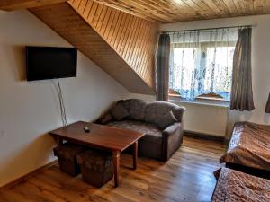 a living room with a couch and a table at Kamień Bałtyku in Debina