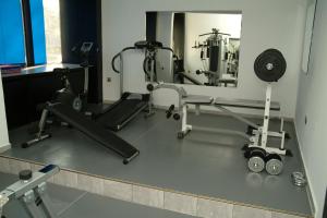 a gym with a mirror and a treadmill and weights at Hotel Dobrudja in Dobrich