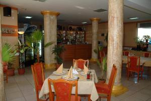 a dining room with a table and chairs and columns at Hotel Dobrudja in Dobrich