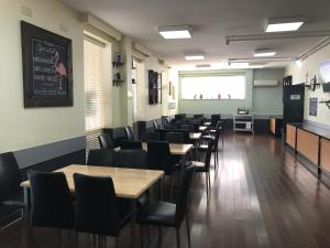 a dining room with tables and chairs and a chalkboard at Miami Hotel Melbourne in Melbourne