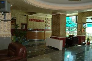 a lobby with a reception desk and leather chairs at Hotel Dobrudja in Dobrich