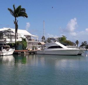 a white boat is docked at a house on the water at Karukera Lodge in Le Gosier