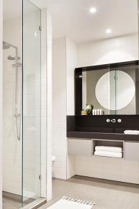 La salle de bains est pourvue d'un lavabo et d'un miroir. dans l'établissement Tyrian Albert Park Lake, à Melbourne