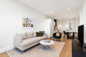 a living room with a couch and a table at Tyrian Albert Park Lake in Melbourne
