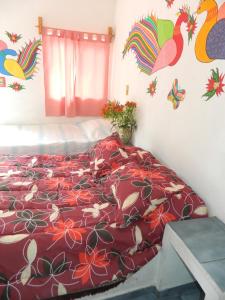 una camera con letto e piumone rosso di Posada Joan Sebastian a Taxco de Alarcón
