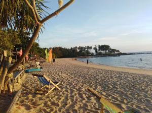 Una playa con sillas y una palmera. en Relax Beach House, en Ko Lanta