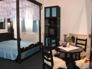 1 dormitorio con 1 cama, 1 mesa, 1 cama, 1 mesa y sillas en Pensiunea Ana Maria, en Târgu Mureș