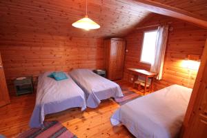 a bedroom with two beds in a log cabin at Mäkelän Lomatuvat Bed and Breakfast in Hyytiälä