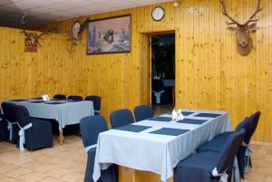 a dining room with two tables and a deer head on the wall at Galitsiya Hotel in Lviv