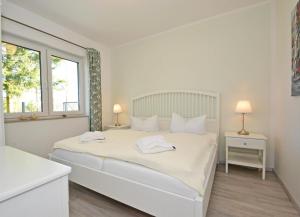 ZirchowにあるFerienhaus Zirchow 4の白いベッドルーム(ベッド1台、タオル2枚付)