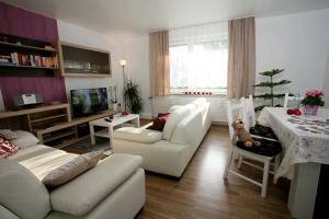 Ferienwohnung Zum alten Zollhaus في بيرغن: غرفة معيشة مع أريكة بيضاء وطاولة