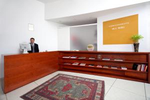 a man standing at a cash register in a lobby at Hotel Due Mori in Marostica