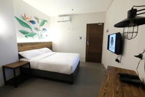 a bedroom with a bed and a tv in it at U Hotels Makati in Manila