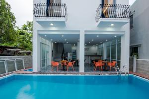 a house with a swimming pool and a patio with a table and chairs at Silver Moon Hotel Hoi An in Hoi An