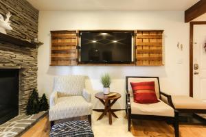 a living room with two chairs and a television at POW HAUS: Modern Beaver Creek 2BR w/ Ski Access in Avon