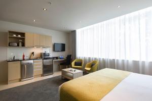 a hotel room with a bed and a kitchen at Quest on Hobson Serviced Apartments in Auckland