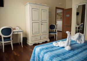 a bedroom with a bed with a dresser and chairs at Stupor Mundi Bed and Breakfast in Palermo