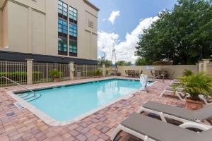 a swimming pool with chairs and a building at Wingate by Wyndham - Universal Studios and Convention Center in Orlando