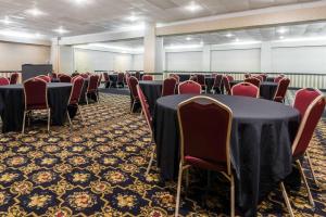 a conference room with tables and red chairs at Baymont by Wyndham Kokomo in Kokomo