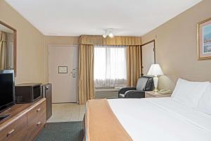 a hotel room with a bed and a television at Howard Johnson by Wyndham Torrance in Torrance