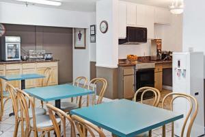 Howard Johnson by Wyndham Torrance في تورانس: مطبخ بطاولات زرقاء وكراسي في مطبخ