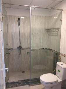 a bathroom with a glass shower with a toilet at HD House in Noi Bai
