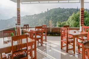 un patio con tavoli, sedie e vista sulle montagne di Bali Bening a Munduk