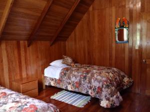 a bedroom with a bed with a cat laying on it at La Cabaña de Noa in Oxapampa